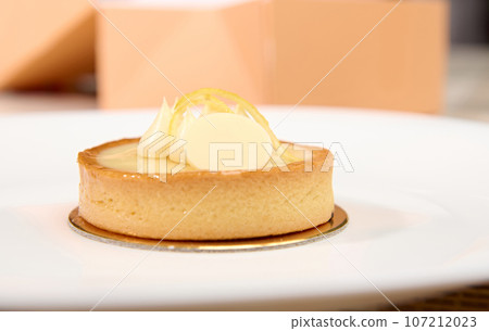 French patisserie. Still life with a delicious tartlet with lemon on a white plate French patisserie. Still life with a delicious tartlet with lemon on a white plate 107212023