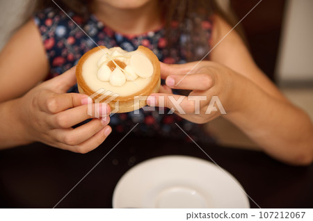Close up of child hands cupped showing a delicious tartlet with lemon. Confectionery. French bakery. Food concept 107212067