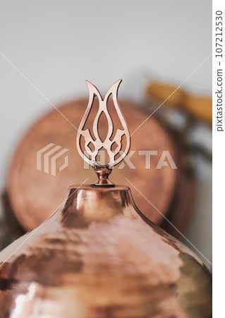 Details of lids with dishes on traditional copper Turkish utensils on a shelf in the kitchen at home or in a restaurant, selective focus. Traditional crafts. Details of lids with dishes on traditional copper Turkish utensils on a shelf in the kitchen at home or in a restaurant, selective focus. Traditional crafts. 107212530