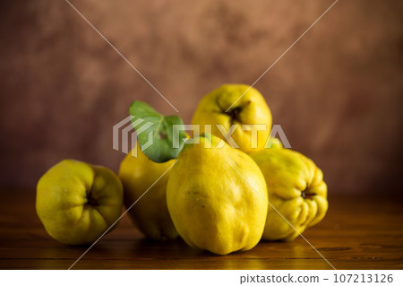 Ripe natural autumn quince on wooden table. 107213126