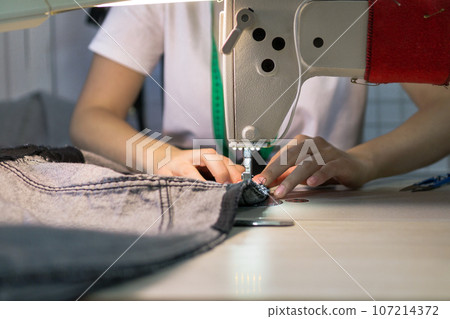 hands of a seamstress working for the machine .close up 107214372
