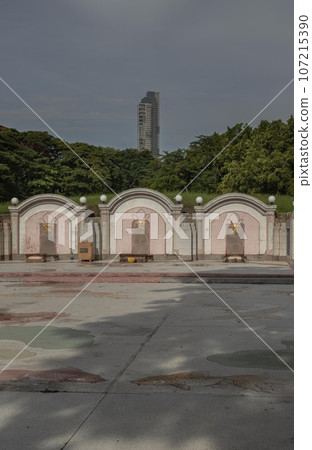 Three Traditional chinese graves are at Chinese cemetery are against the modern building and sky background. Three Traditional chinese graves are at Chinese cemetery are against the modern building and sky background. 107215390