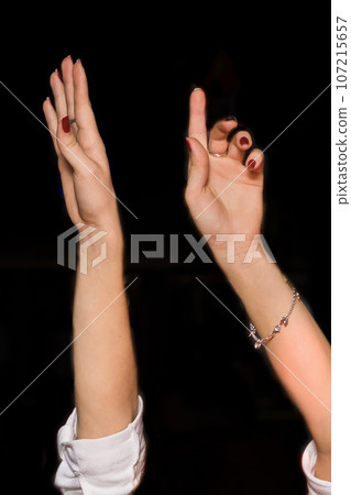 Women's hands up gesture of a girl's hand while dancing on a black background, close up Women's hands up gesture of a girl's hand while dancing on a black background, close up 107215657