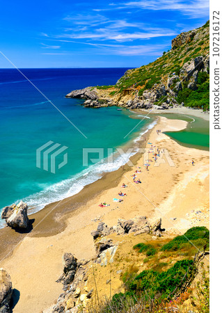 View of sandy beach of Preveli, Crete island, Greece on clear sunny day. Travel destination, river and clear Lybian sea waters, forest, palm trees, gorge, blue sky with clouds. Tourist swim and View of sandy beach of Preveli, Crete island, Greece on clear sunny day. Travel destination, river and clear Lybian sea waters, forest, palm trees, gorge, blue sky with clouds. Tourist swim and 107216172
