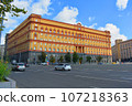 A building in warm colors against a blue sky 107218363