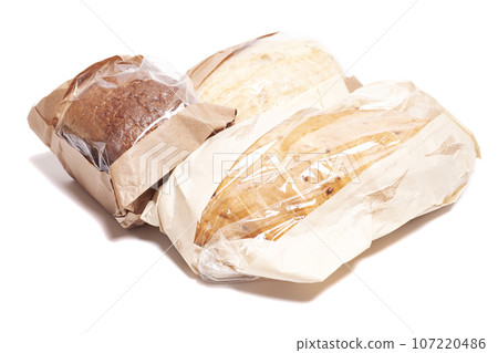 Rye and white bread in a paper bag isolated on white background. Rye and white bread in a paper bag isolated on white background. 107220486