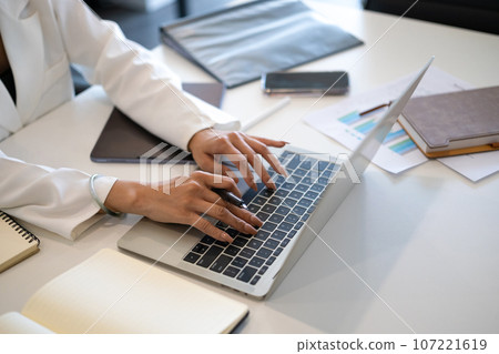 Close up businesswoman hands typing on laptop searching information, web surfing internet or texting email 107221619