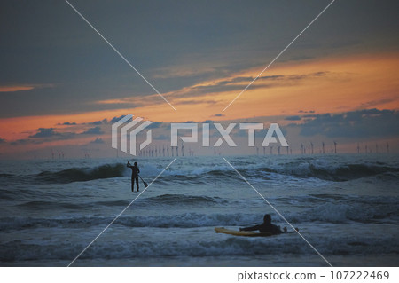Surfer in the North Sea in the Netherlands at night Surfer in the North Sea in the Netherlands at night 107222469