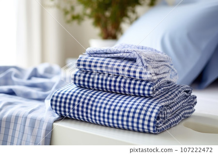 a clean pair of pajamas folded on a bed 107222472