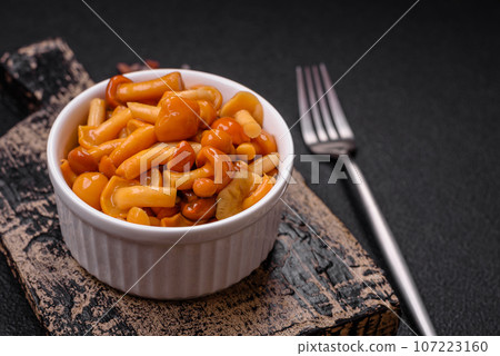 Delicious pickled honey mushrooms with salt and spices in a ceramic plate Delicious pickled honey mushrooms with salt and spices in a ceramic plate 107223160