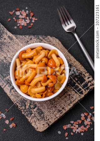 Delicious pickled honey mushrooms with salt and spices in a ceramic plate Delicious pickled honey mushrooms with salt and spices in a ceramic plate 107223161