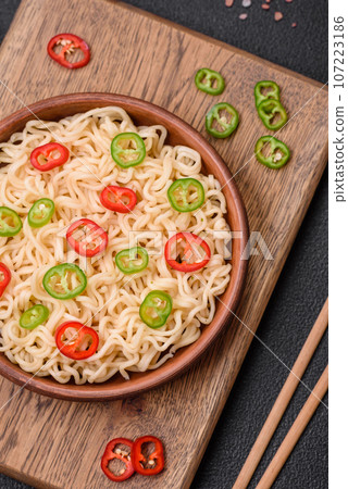 Delicious Asian cuisine dish with rice noodles, peppers, mushrooms and spices Delicious Asian cuisine dish with rice noodles, peppers, mushrooms and spices 107223186