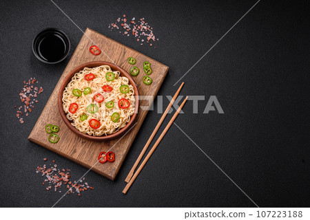 Delicious Asian cuisine dish with rice noodles, peppers, mushrooms and spices 107223188