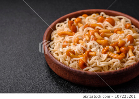 Delicious Asian cuisine dish with rice noodles, peppers, mushrooms and spices 107223201