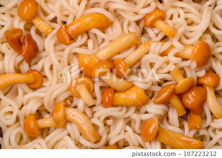 Delicious Asian cuisine dish with rice noodles, peppers, mushrooms and spices 107223212