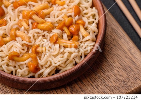 Delicious Asian cuisine dish with rice noodles, peppers, mushrooms and spices 107223214