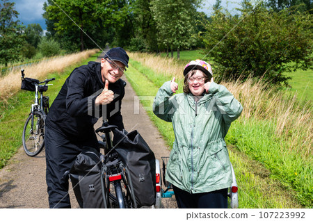 Outdoor portrait of a 40 yo woman with the Down Syndrome and her brother, Belgium Outdoor portrait of a 40 yo woman with the Down Syndrome and her brother, Belgium 107223992