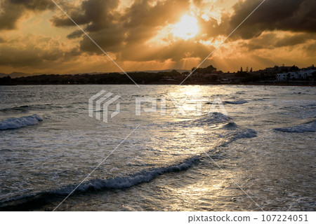 Fabulously shaped wave breaking on a sandy beach at sunrise in Crete Fabulously shaped wave breaking on a sandy beach at sunrise in Crete 107224051