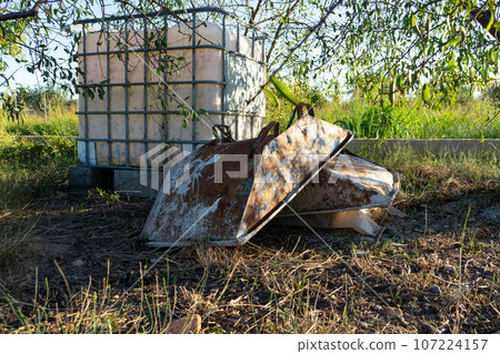 Image of metal containers to make concrete stacked in a field, oxidized and old due to the time that they lead to the interperie. 107224157