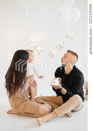 Caring parents greeting daughter with birthday cake indoors 107224300