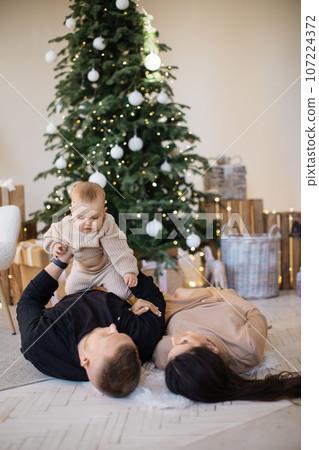 Mother, father and daughter lying on floor at decorated home 107224372