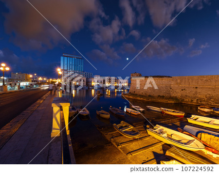 Night in Gallipoli, province of Lecce, Puglia, southern Italy.  People and signs unrecognizable. 107224592
