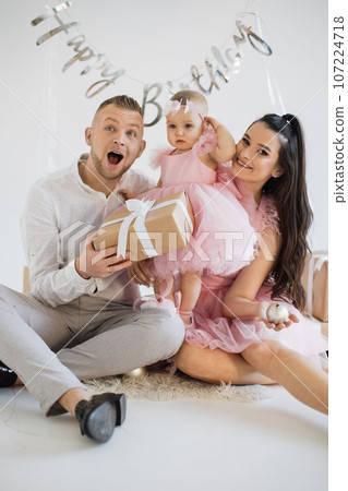 Parents with daughter celebrating birthday in decorated room Parents with daughter celebrating birthday in decorated room 107224718