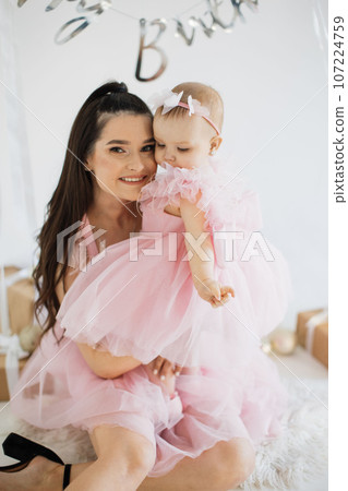 Mother with daughter posing in studio with birthday decor Mother with daughter posing in studio with birthday decor 107224759