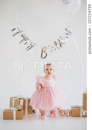 Little girl standing in studio with decorations for birthday 107224789