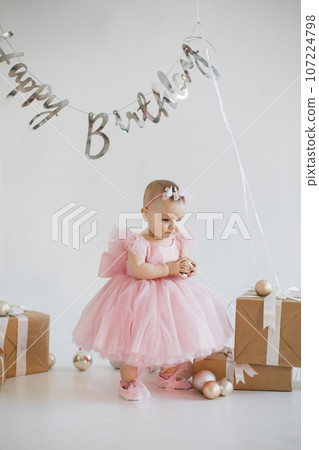 Little girl standing in room filled with holiday decorations Little girl standing in room filled with holiday decorations 107224798