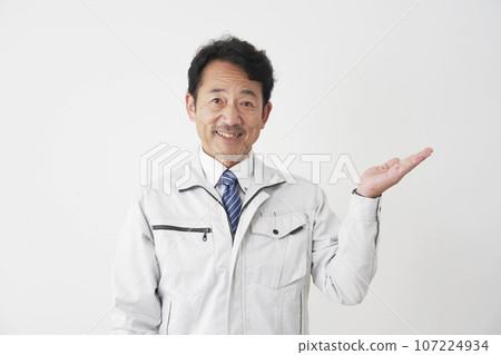 Worker pointing to the right side with the palm of his hand, white background 107224934