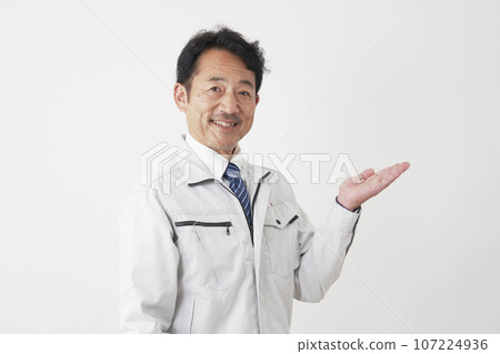 Worker pointing to the right side with the palm of his hand, white background 107224936
