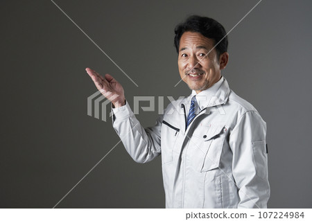 工人用手掌指向左側，黑色背景 107224984