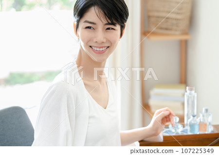 A woman doing skin care in her room A woman doing skin care in her room 107225349