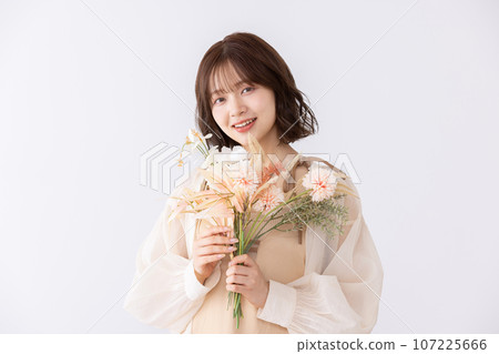 One-piece woman holding a bouquet of dried flowers One-piece woman holding a bouquet of dried flowers 107225666