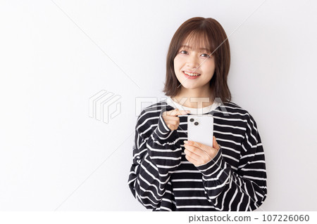 Young woman using a smartphone Young woman using a smartphone 107226060