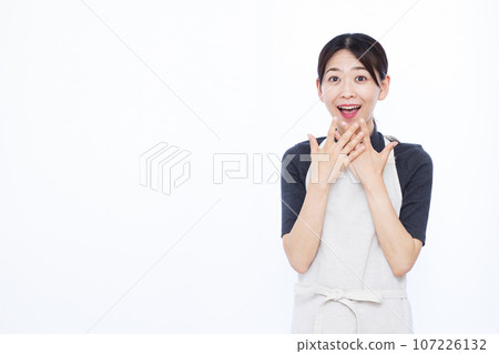 一位 30 多歲的家庭主婦在白色背景前微笑著 一位 30 多歲的家庭主婦在白色背景前微笑著 107226132
