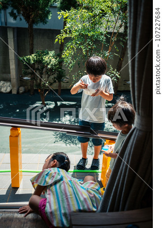 Children enjoying gutter-nagashi somen noodles in the garden Children enjoying gutter-nagashi somen noodles in the garden 107227684