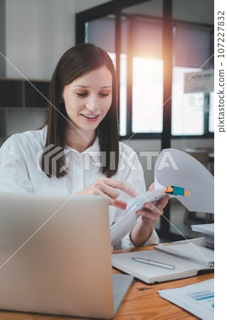 Business woman using business paper for doing math finance on office desk, tax, report, accounting, statistics, and analytical research concept 107227832