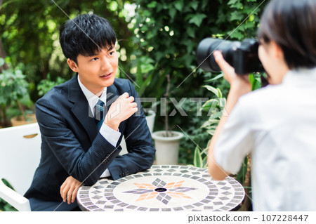女性商業攝影師為男性拍攝個人資料照片 107228447