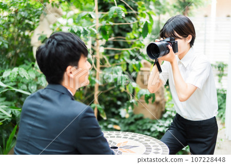 Female business photographer taking profile photos of men 107228448