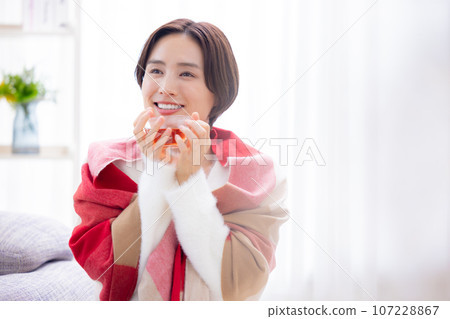 Woman relaxing in the living room Woman relaxing in the living room 107228867