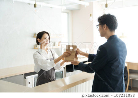 Cafe clerk and customer handing over products Cafe clerk and customer handing over products 107231058