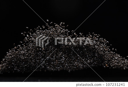 Black Sesame seeds flying explosion, black grain wave floating. Abstract cloud fly splash in air. Sesame seed is material food. Black background Isolated selective focus blur Black Sesame seeds flying explosion, black grain wave floating. Abstract cloud fly splash in air. Sesame seed is material food. Black background Isolated selective focus blur 107231241