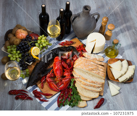 Smoked sturgeon with lobster, crayfishes, bread, cheese, fruits and wine Smoked sturgeon with lobster, crayfishes, bread, cheese, fruits and wine 107231975