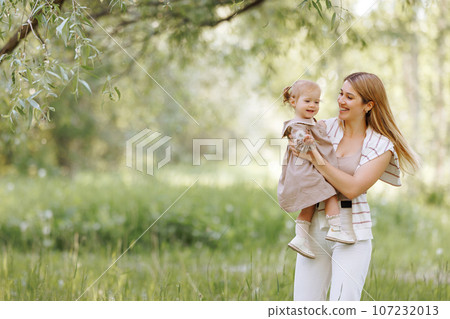 Young european woman in casual clothes with a small child Young european woman in casual clothes with a small child 107232013