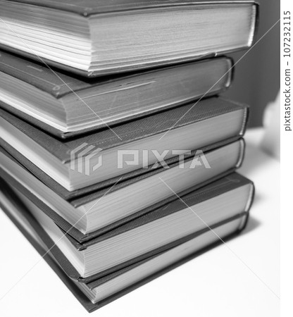 Stack of books on a white background. One book is yellow. Book reading and learning concept. 107232115