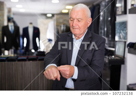 Mature male shopper shows off his jacket at men's store Mature male shopper shows off his jacket at men's store 107232138