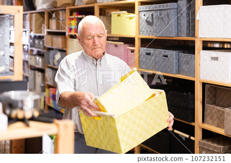 Mature buyer man choices bathroom boxes at hardware store 107232151