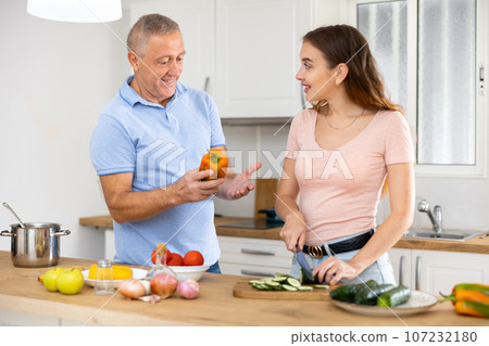 Happy father together with his adult daughter prepares a festive dinner 107232180